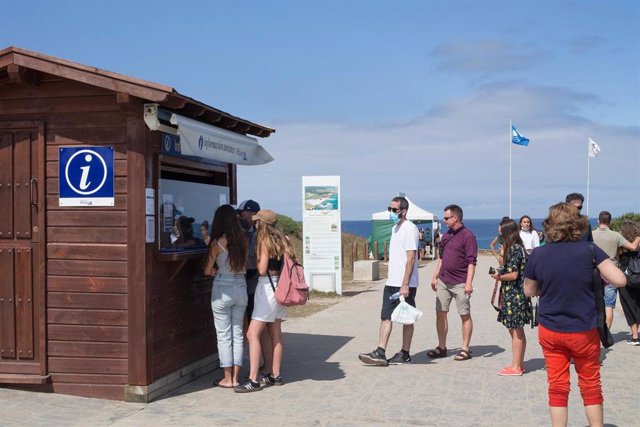 Turistas hacen cola ante una oficina de información turística