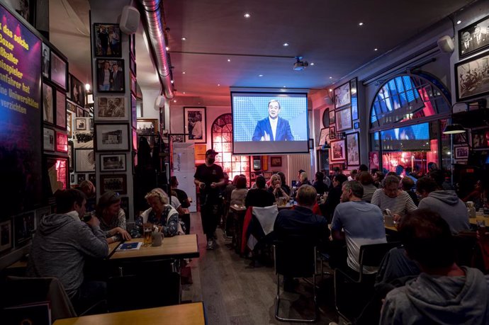 29 August 2021, Berlin: Visitors of the pub Standige Vertretung follow the Armin Laschet, Minister President of North Rhine-Westphalia and candidate for chancellor of the Christian Democratic Union (CDU), as he takes part in the first TV discussion on R