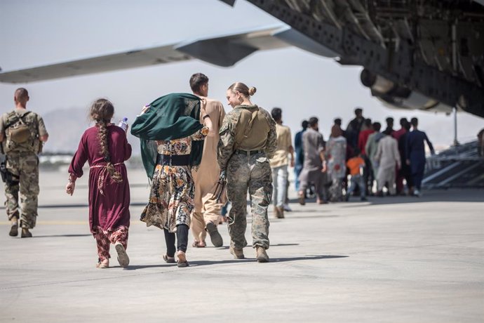 24 August 2021, Afghanistan, Kabul: A US marine escorts Afghan children during an evacuation at Hamid Karzai International Airport following the Taliban takeover. Photo: -/Planet Pix via ZUMA Press Wire/dpa