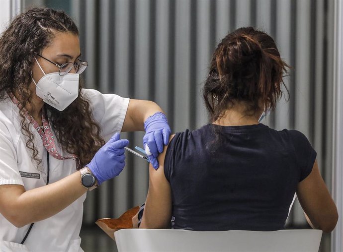 Archivo - Una joven recibe la vacuna contra el Covid-19 en el dispositivo puesto en marcha en la Ciutat de les Arts i les Cincies de Valencia.