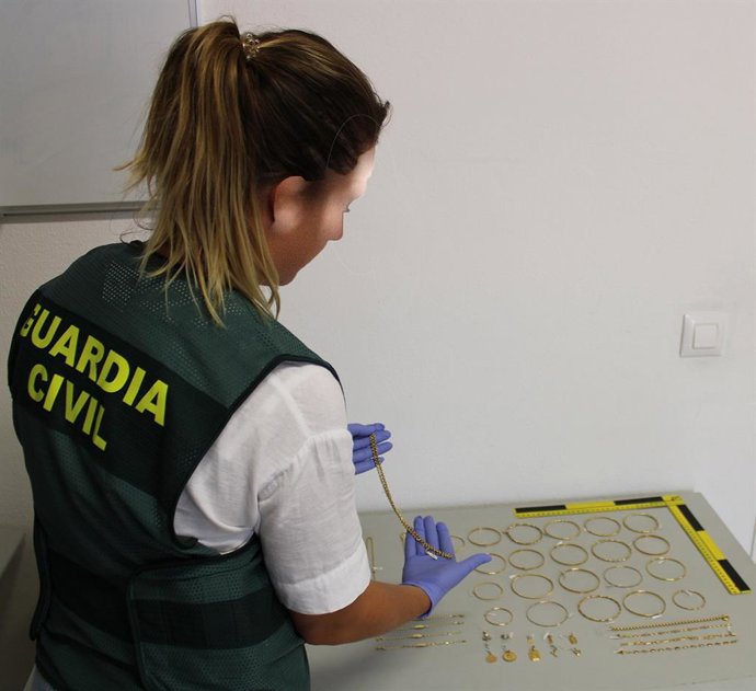 Una agente de la Guardia Civil con las joyas localizadas.