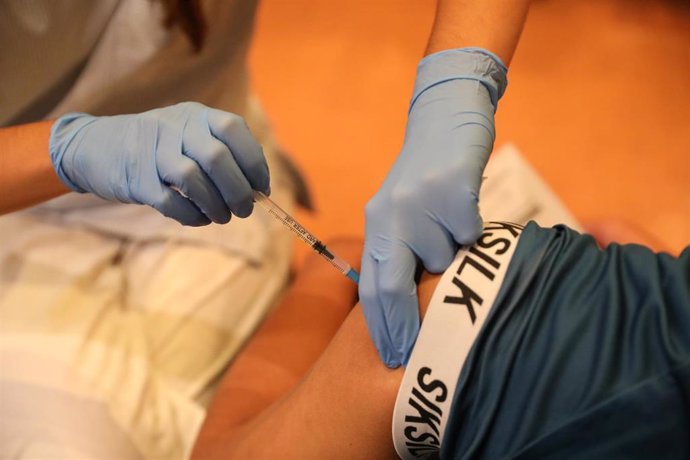 Una sanitaria vacuna a una persona contra el coronavirus con una dosis de Pfizer, en el dispositivo puesto en marcha en las instalaciones del Hospital General Universitario Gregorio Marañón, a 20 de agosto de 2021, en Madrid (España). Casi 5 millones de