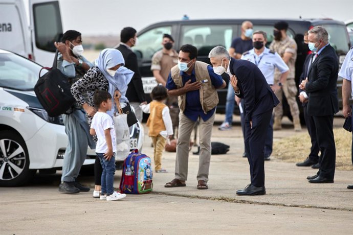 El ministro de Interior, Fernando Grande-Marlaska (2i), saluda a un niño refugiado en la base aérea de Torrejón de Ardoz a 24 de agosto de 2021, en Madrid (España). Este octavo avión militar enviado por el Gobierno de España, que antes de llegar a Madri