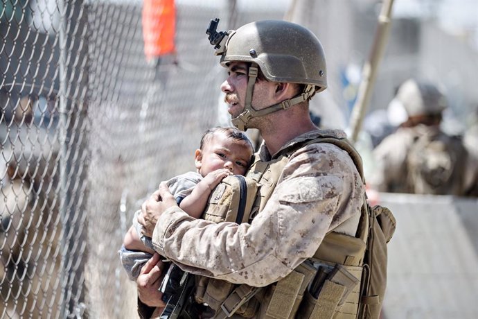 28 August 2021, Afghanistan, Kabul: Asoldier of the Special Purpose Marine Air-Ground Task Force Crisis Response team, holds an infant waiting for evacuation at Hamid Karzai International Airport during Operation Allies Refuge in Kabul. Photo: Sgt. Sam