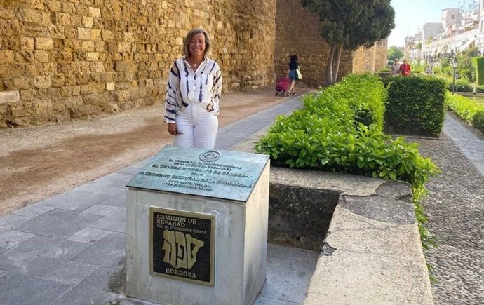 Isabel Albás junto a la placa de la Red de Juderías.