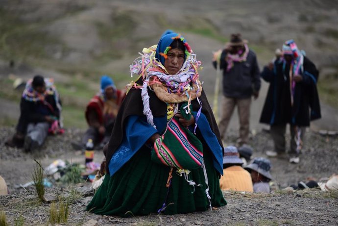 Archivo - Una mujer indígena de Bolivia carga una bolsa con hoja de coca. 