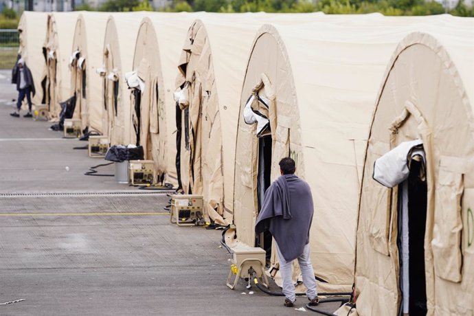 30 August 2021, Rhineland-Palatinate, Ramstein-Miesenbach: A man evacuated from Afghanistan stands among a row of tents at Ramstein Air Base. The US is using its military base in Ramstein, Palatinate, as a hub for the evacuation of shelter seekers and l