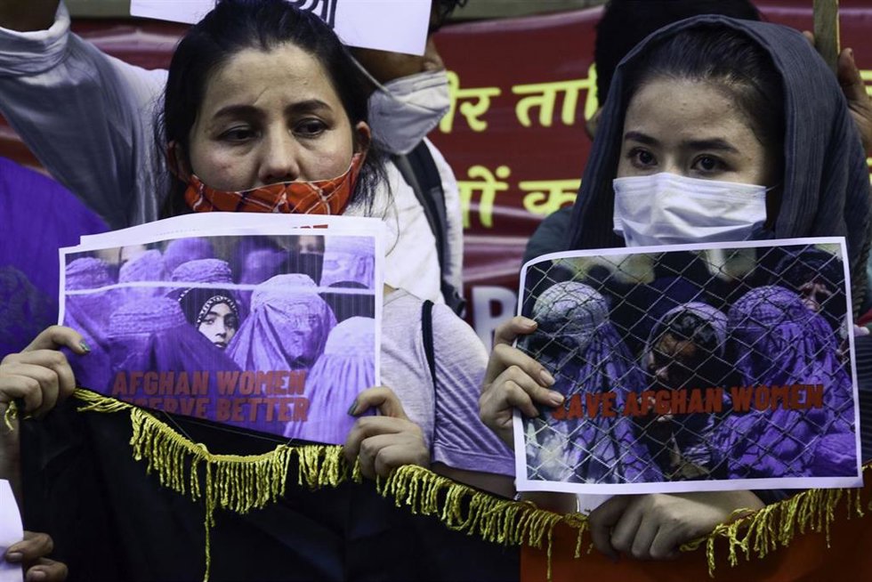 Refugiados afganos sostienen pancartas durante una manifestación contra los talibanes en la que exigen protección para las mujeres en Afganistán tras la toma del poder por parte de los talibán.