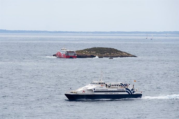 Un barco pasa cerca del ferry 'San Gwann' de la naviera FRS encallado en el islote norte de Es Malvins. 