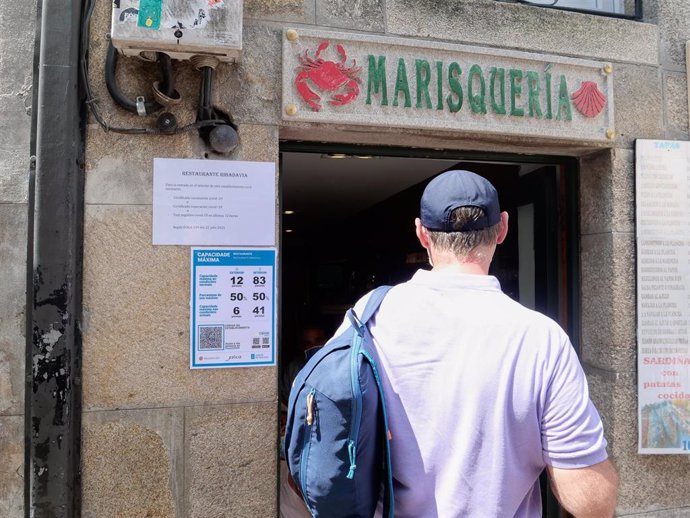 Varias indicaciones de obligatoriedad de presentar certificados antes de acceder al interior, en una marisquería de la Rua do Franco,  en Santiago de Compostela