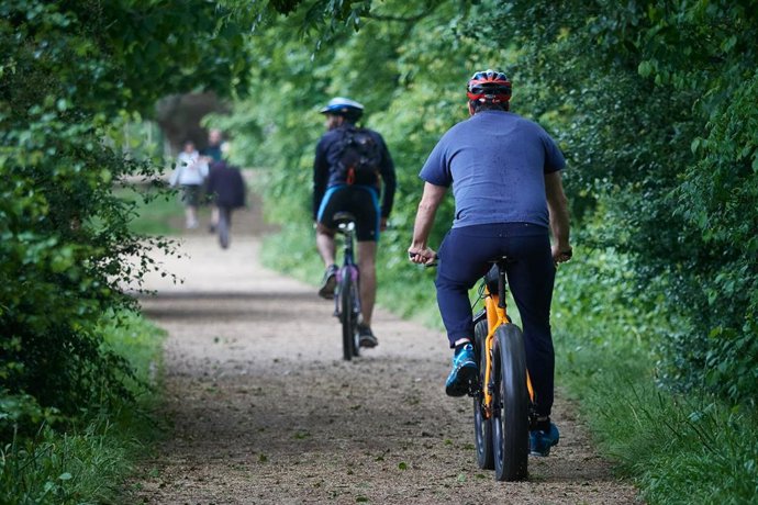 Archivo - Varias personas montando en bicicleta