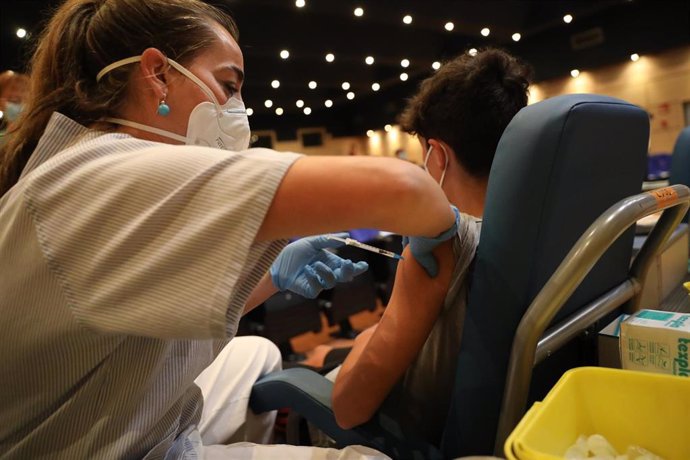 Una sanitaria vacuna a un menor  contra el coronavirus con una dosis de Pfizer, en el dispositivo puesto en marcha en las instalaciones del Hospital General Universitario Gregorio Marañón, a 20 de agosto de 2021, en Madrid (España). Casi 5 millones de p
