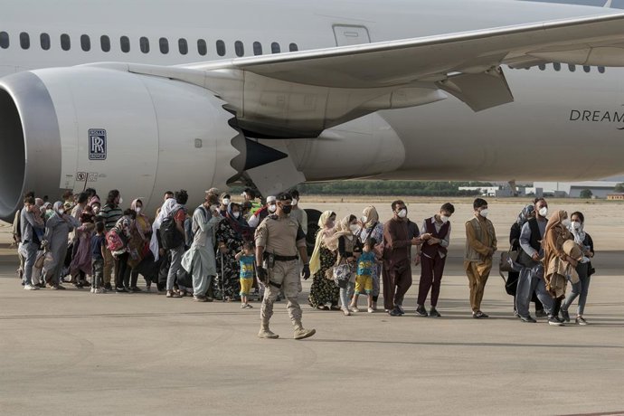 Varias personas, entre ellas niños llegan a la base aérea de Torrejón de Ardoz, procedentes de Afganistán, a 23 de agosto de 2021, en Madrid (España). Un total de siete aviones han salido desde el aeropuerto de Kabul hacia la base de Torrejón con evacua