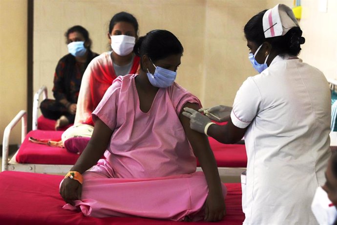 Archivo - Una mujer es vacunada contra el coronavirus en India.