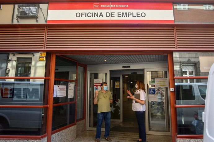 Dos personas conversan a las puertas de una oficina del SEPE de Evaristo San Miguel de Arguelles