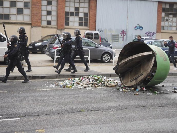 Contenedor volcado en las inmediaciones del gaztetxe de la Rochapea de Pamplona, adonde han acudido agentes de la Policía Nacional para proceder a su desalojo.