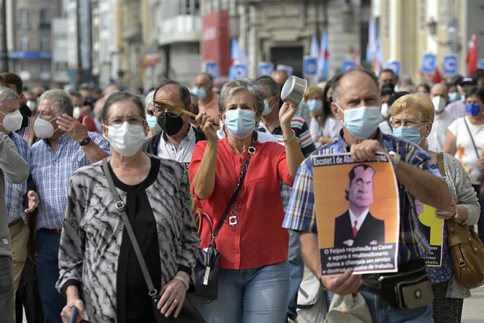 Una persona sostiene una pancarta durante la manifestación contra el cierre de oficinas de la entidad Abanca ante la sede de Abanca en A Coruña, a 2 de septiembre de 2021, en A Coruña, Galicia, (España). 