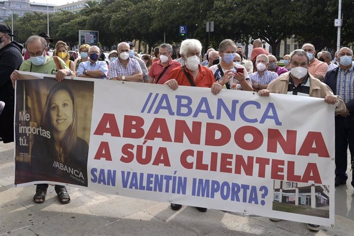 Un grupo de personas sostienen una pancarta durante la manifestación contra el cierre de oficinas de la entidad Abanca ante la sede de Abanca en A Coruña, a 2 de septiembre de 2021, en A Coruña, Galicia, (España). 