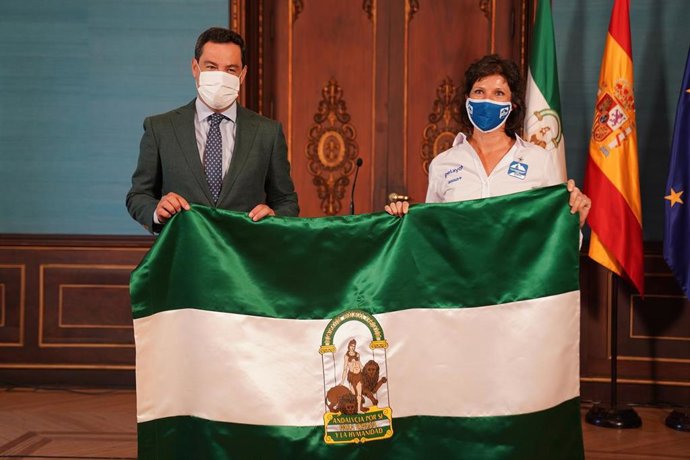 El presidente de la Junta de Andalucía, Juanma Moreno, ha entregado la bandera de Andalucía a la malagueña Susana Ruiz, participante del Reto Pelayo Vida.
