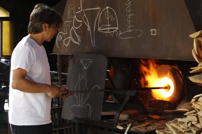 Un vidriero fabrica vidrio en el horno mediante la técnica del vidrio soplado, en la Fábrica de Vidrios de Arte Gordiola, a 25 de agosto de 2021, en Algaida, Mallorca, Islas Baleares (España). 