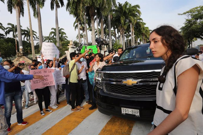 27 August 2021, Mexico, Tuxtla Gutierrez: Andres Manuel Lopez Obrador, President of Mexico, in his vehicle as several dozen of demonstrators from the teachers' union CNTE are surrounding the SUV in front of the main barracks of the armed forces in the s