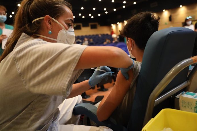 Una sanitaria vacuna a un menor  contra el coronavirus con una dosis de Pfizer, en el dispositivo puesto en marcha en las instalaciones del Hospital General Universitario Gregorio Marañón, a 20 de agosto de 2021, en Madrid (España). 