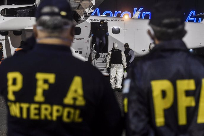 Archivo - 15 May 2020, Argentina, Buenos Aires: Interpol officials wait for the arrival of Gonzalo Sanchez, a former Argentine naval officer who is allegedly implicated in dictatorship-era crimes, at Ezeiza airport after his extradition from Brazil. Pho