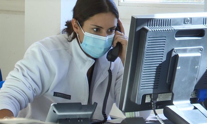 Archivo - Una profesional sanitaria atiende un teléfono