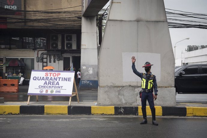 Archivo - 16 March 2020, Philippines, Metro Manila: A police officer wearing a face mask monitors incoming traffic at a checkpoint amid fears pf the spread of Coronavirus (Covid-19). Philippine President Rodrigo Duterte on Monday ordered nearly 60 milli
