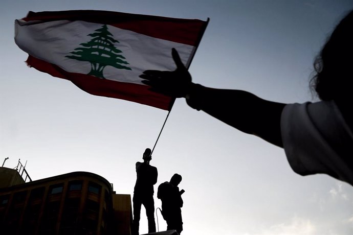 Archivo - 03 November 2019, Lebanon, Beirut: Protestors wave the national flag during an anti-government protest in downtown Beirut. Demonstrators took the streets across Lebanon to protest against the government for the 18th consecutive day. Photo: Mar