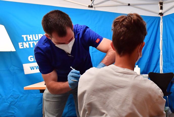 25 August 2021, Thuringen, Erfurt: Johannes Hille (L), medical assistant and paramedic, vaccinates a student with a COVID-19 vaccine d uring a mobile vaccination campaign. Photo: Martin Schutt/dpa-Zentralbild/dpa