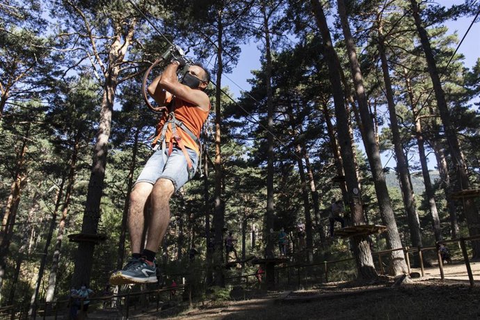 Imagen de recurso de una persona descendiendo en tirolina.