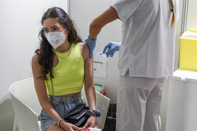 Una sanitaria vacuna a una adolescente con la primera dosis de la vacuna Moderna en la Ciudad de las Artes, a 16 de agosto de 2021, en Valencia, Comunidad Valenciana, (España). La Generalitat Valenciana ha arrancado esta semana la citación para todas la