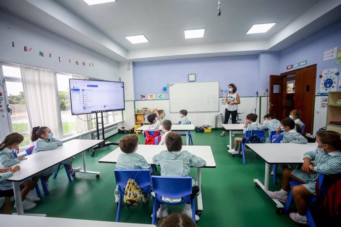 Varios niños escuchan las explicaciones de su profesora en una clase del colegio Virgen de Europa durante el primer día de clase del curso 2021-22, a 6 de septiembre de 2021, en Boadilla del Monte, Madrid (España). 
