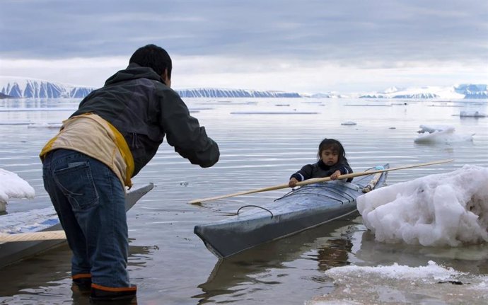 En la foto, un adulto enseña a un niño a remar cerca de Siorapaluk en el noroeste de Groenlandia.