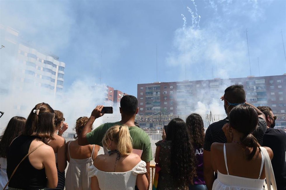 Asistentes a una de las 'mascletaes' de los actos falleros de 2021 en Valncia, celebradas fuera de la plaza del Ayuntamiento y en distintos puntos de la ciudad para evitar concentraciones de gente ante la pademia de la Covid-19. 