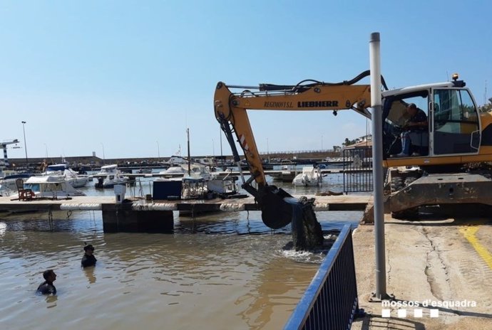 Imatge de la grua que ajuda a restablir la situació al Port d'Alcanar (Tarragona)