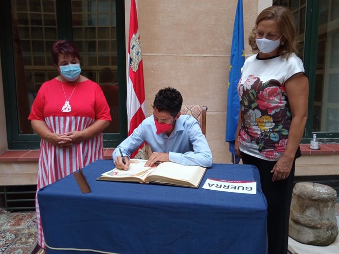 El atleta Javier Guerra firma en el Libro de Honor del Ayuntamiento de su ciudad en presencia de la alcaldesa, Clara Luquero (izq).
