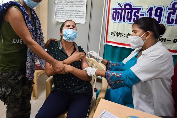 Archivo - Una mujer recibe su dosis de la vacuna contra el coronavirus en un centro médico de Prayagraj, noreste de India.