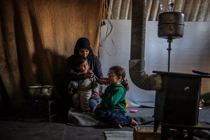 Archivo - 13 March 2021, Lebanon, Aarsal: Haifa, a 23-year-old Syrian refugee woman, feeds her daughter and son inside their tent at the Lebanese town of Aarsal, located north-east of capital Beirut. UNICEF said that after 10 years since the start of th