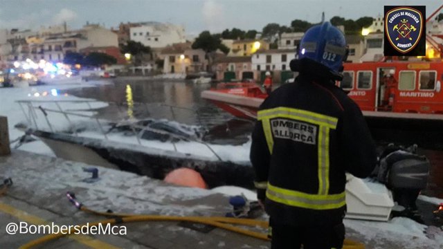 Un bombero frente a la embarcación incendiada en Portopetro.