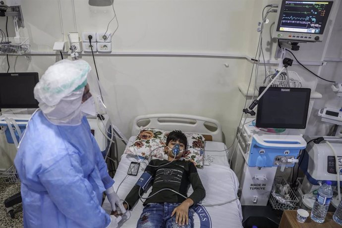 FILED - 25 August 2021, Syria, Salqin: A medic in protective clothing attends to a boy suspected of having contracted coronavirus, inside the intensive care ward of the Syrian American Medical Society (SAMS) Foundation. According to the Early Warning, A