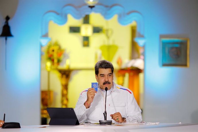 Archivo - HANDOUT - 28 March 2021, Venezuela, Caracas: Nicolas Maduro, president of Venezuela, holds a copy of the Venezuelan constitution during a press conference. Maduro has offered to swap oil for COVID-19 vaccines in view of rapidly rising coronavi