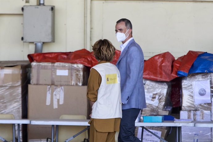 El Rey Felipe VI conversa con una cooperante a su llegada al hangar para visitar el dispositivo provisional en Torrejón de Ardoz, a 28 de agosto de 2021, en Torrejón de Ardoz, Madrid, (España). El campamento se ha instalado provisionalmente para recibir