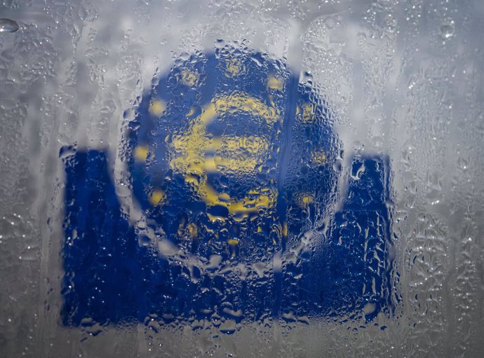 Archivo - FILED - 19 March 2020, Hessen, Frankfurt_Main: Water droplets slide down the glass covering the euro symbol at the south entrance to the headquarters of the European Central Bank (ECB). The global economy will contract 3 per cent this year due