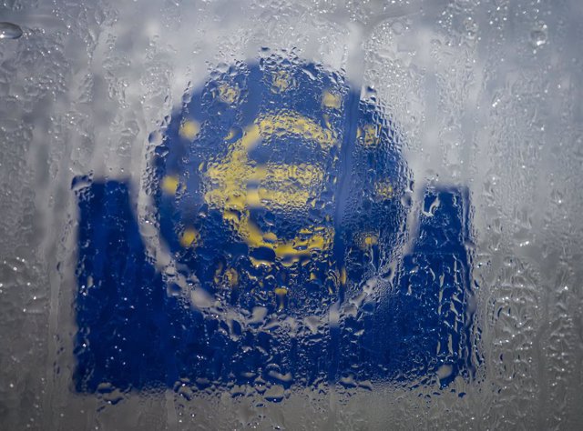 Archivo - FILED - 19 March 2020, Hessen, Frankfurt_Main: Water droplets slide down the glass covering the euro symbol at the south entrance to the headquarters of the European Central Bank (ECB). The global economy will contract 3 per cent this year due t