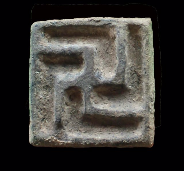 Archivo - Imagen del sello de bronce con la cruz gamada encontrado en el nuevo santuario Ibérico en la Cueva de las Brujas, en Santomera