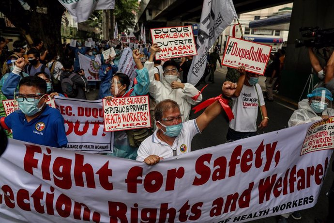 01 September 2021, Philippines, Manila: Hospital workers and health activists hold signs during a protest in front of the Department of Health headquarters in Manila demanding for the immediate release of COVID-19 funds allocated for support to healthca