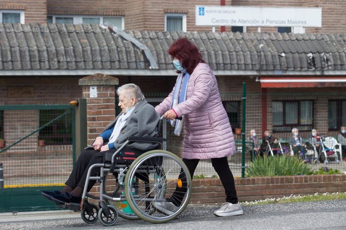 Archivo - Una mujer pasea a una anciana en silla de ruedas, en las inmediaciones de la residencia geriátrica de As Gándaras para visitar a un familiar, a 17 de abril de 2021, en Lugo, Galicia (España). Una de las nuevas medidas incluidas en la desescala