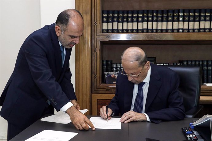 HANDOUT - 10 September 2021, Lebanon, Baabda: Lebanese President Michel Aoun (R) signs a decree to form a long-awaited government comprising 24 ministers in an effort to tackle the country's worst economic crisis since the 1975-1990 civil war ended. Pho